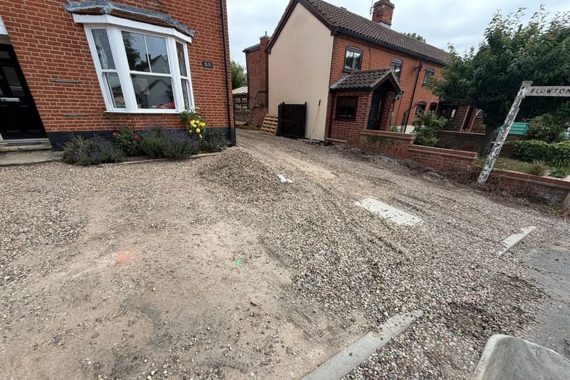A driveway with the crushed stone sub base laid and compacted and the block edge course set, before the surface went down.