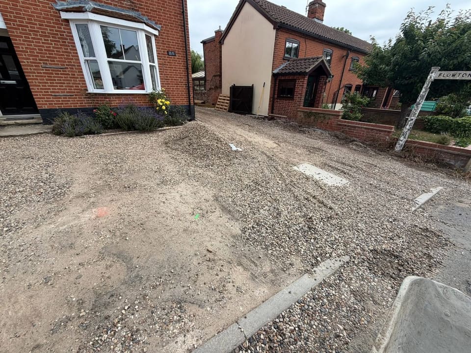 A driveway with the crushed stone sub base laid and the block edge course set, before the surface went down.
