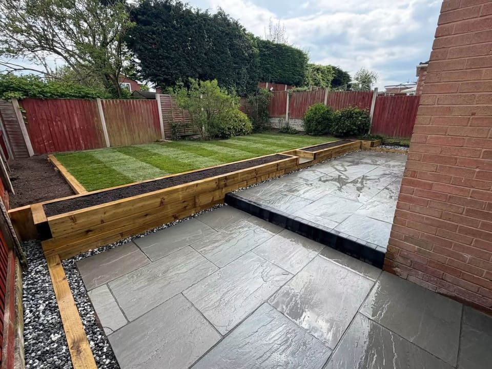 A finished garden: riven porcelain paving, a sleeper retaining edge and freshly laid striped turf.