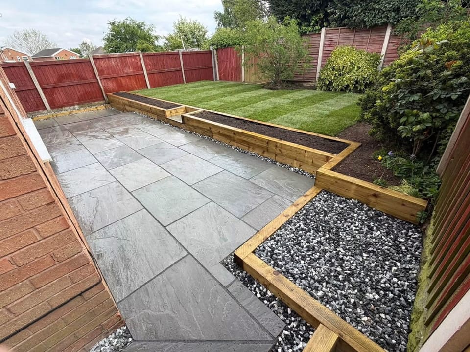 Finished riven porcelain running to a timber sleeper retaining edge and new turf.