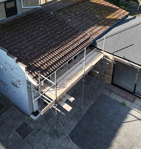 The same roof from the same spot before the work, under old mossy pantiles.