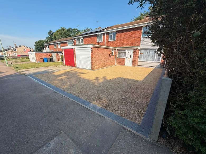 A finished gravel driveway with a charcoal block paved edge and a new tarmac apron at the road.