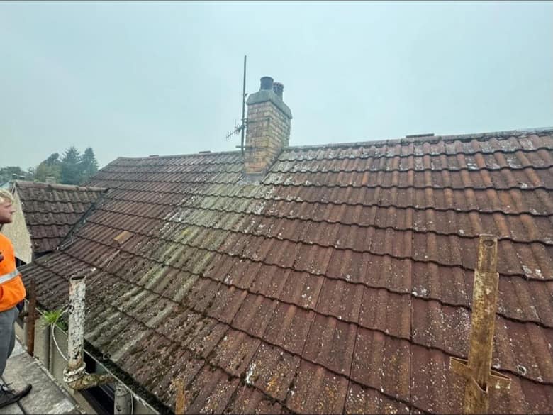 A roof slope photographed from the scaffold, with the eaves and the gutter line running along the bottom of the frame.